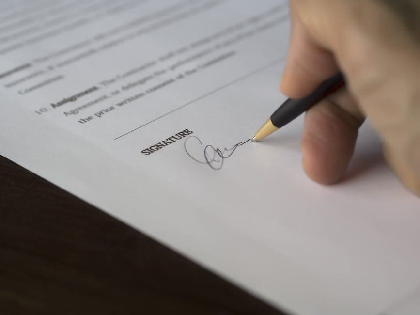 A witness preparing to sign Form 74.8 affidavit of execution while a notary explains the jurat across a wooden desk in Ottawa