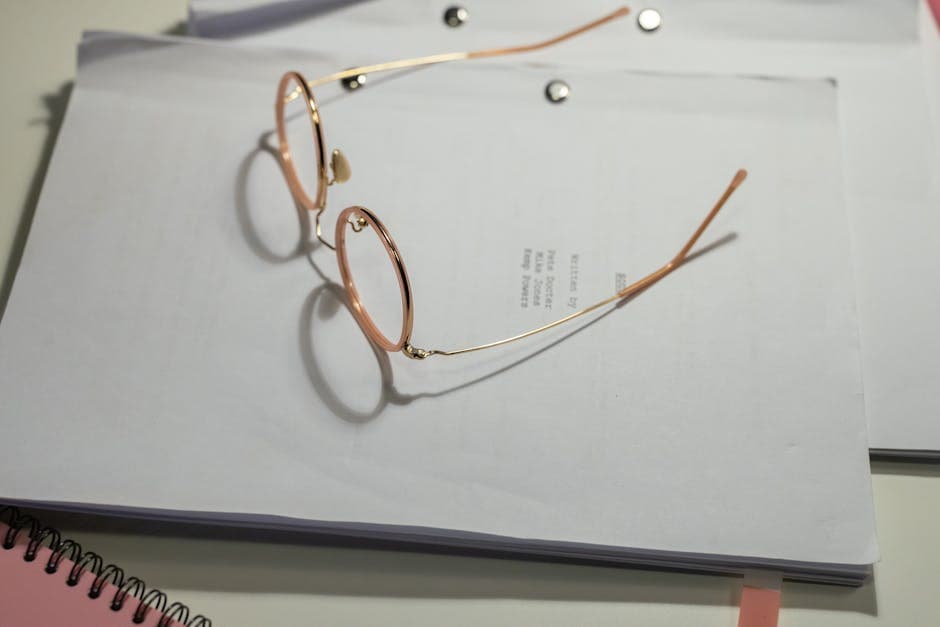 Reading glasses resting on a stack of estate documents — careful review at the boundary of notary and lawyer work