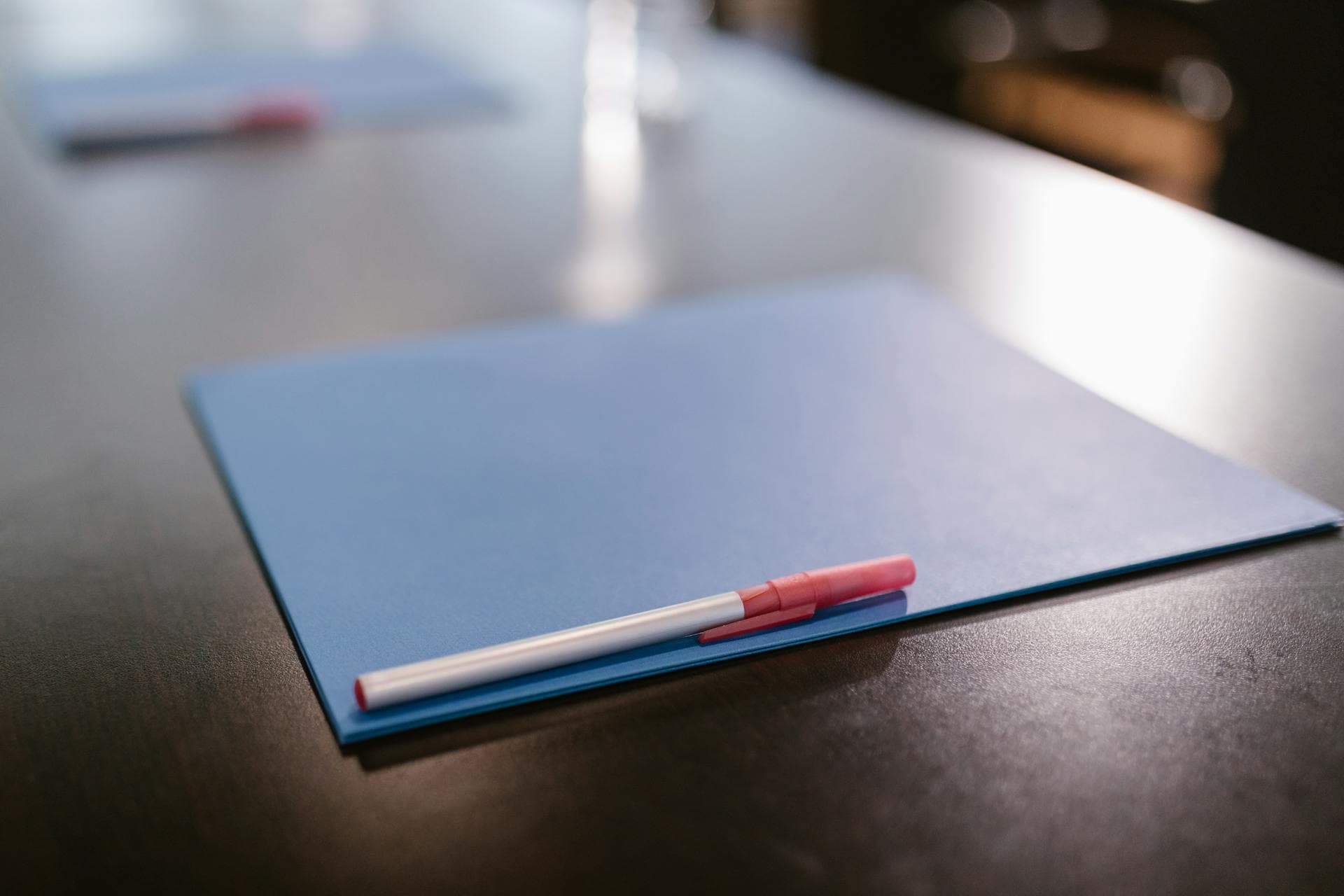 Closed folder of legal documents resting on a hospital bedside table, calm warm light