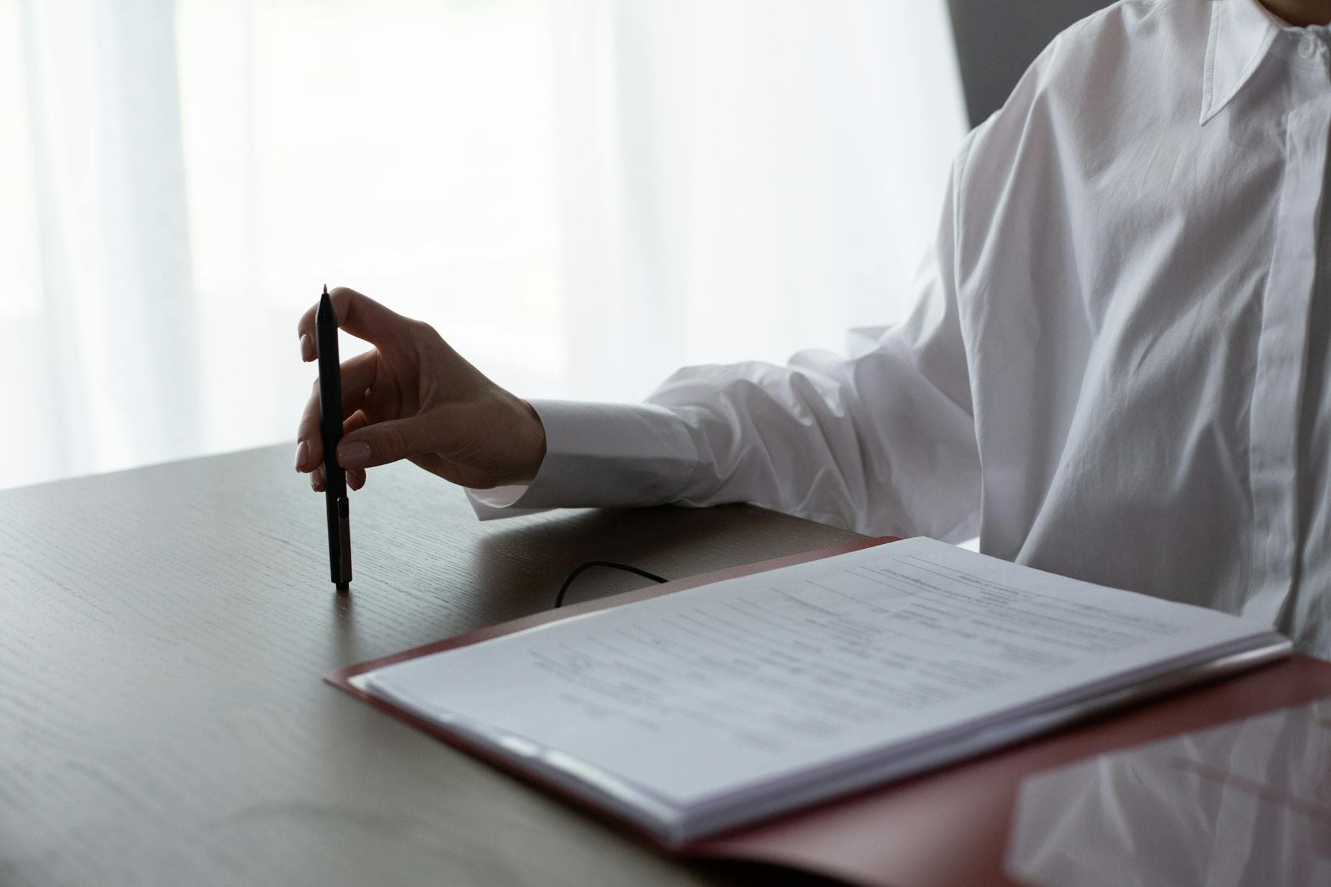 Lawyer reviewing documents in a quiet office before a bedside visit, soft daylight