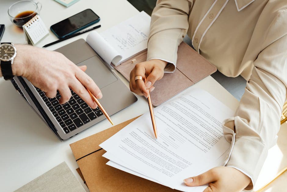 A bilingual Ottawa notary public reviewing a Quebec-bound document and pointing a client to a Quebec notaire's directory on a laptop screen