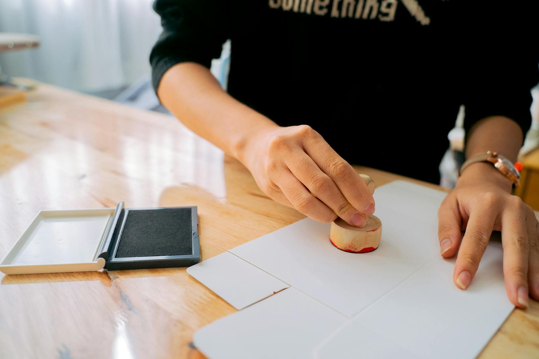 A notary public sealing a travel consent letter with an embossing stamp on a desk in Ottawa, with the original child's passport visible