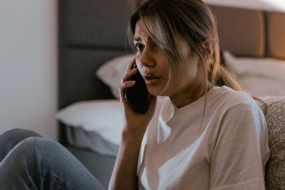 An adult at a kitchen table at night, phone in hand, looking up same-day notary Ottawa options