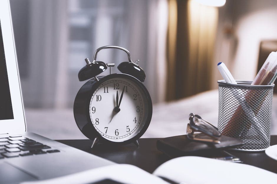 A tidy notary office desk with a wall clock and a small stack of documents
